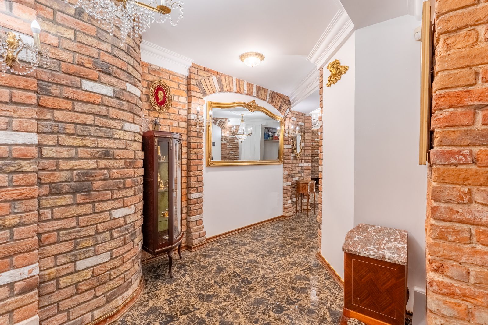 Vaulted room with chandelier, antique dresser and marble floor — Underground Kingdom, Kaunas